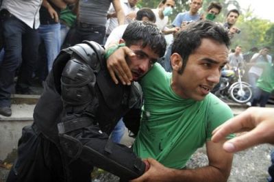 A demonstrator rescues a beleaguered riot policeman, Iran, 13 June 2009