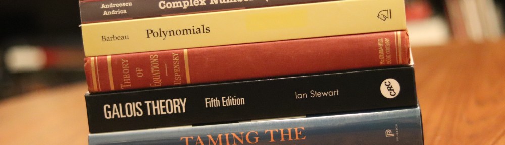 A photograph of a stack of seven small math books on a wooden table.